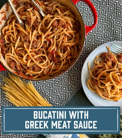 Sfoglini Pasta Recipe:  Bucatini with Greek meat sauce in a red pot and on a white plate, with text overlay "Bucatini with Greek Meatsauce"