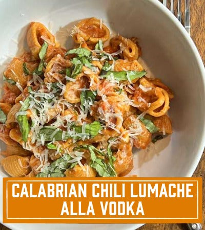 Sfoglini Pasta Recipe: Pasta dish with chili lumache alla vodka in a white bowl on a wooden surface. with text overlay "Calabriam chili lumache alla vodka"
