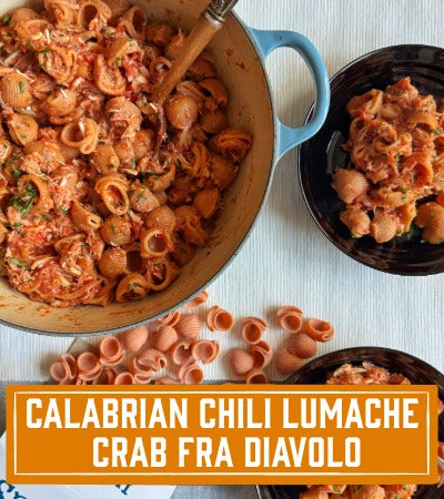 Sfoglini Pasta Recipe: Pasta dish with a wooden spoon in a blue pot, text overlay 'Calabrian Chili Lumache Crab Fra Diavolo'.