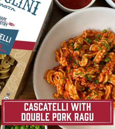 Sfoglini Pasta Recipe: Cascatelli with Double Pork Ragu in a white bowl with a box of  pasta in the background. with text overlay "Cascatelli with Double Pork Ragu"