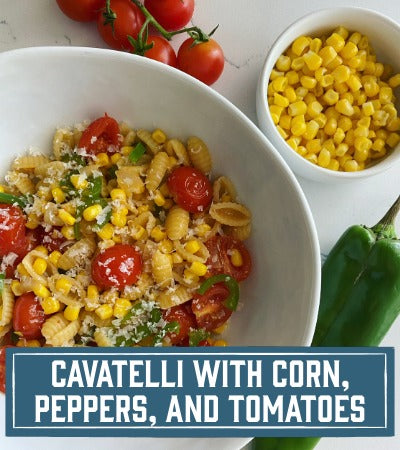 Sfoglini Pasta Recipe:  Cavatelli pasta with corn, peppers, and tomatoes in a white bowl on a white background. vWith text overlay "Cavatelli with Corn, peppers, and tomatoes"