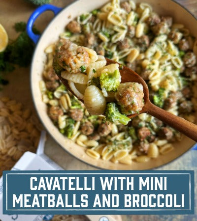 Sfoglini Pasta Recipe:  pasta with mini meatballs and broccoli in a white bowl with a wooden spoon. With text overlay "Cavatelli with mini meatballs and broccoli"