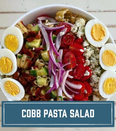 Sfoglini Pasta Recipe:  Cobb pasta salad with Zucca, eggs, tomatoes, and other ingredients in a bowl on a wooden surface. With text overlay "Cobb Pasta Salad"