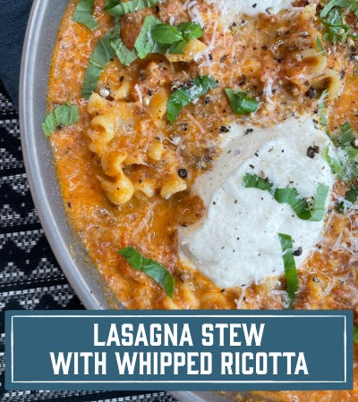 Sfoglini Pasta Recipe:  Reginetti pasta Lasagna stew with whipped ricotta and fresh basil in a bowl. With text overlay "Lasagna stew with whipped ricotta"
