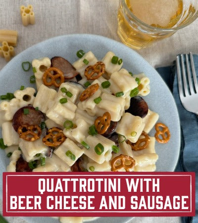Sfoglini Pasta Recipe: Pasta dish with beer cheese and sausage on a plate, accompanied by a glass of beer. With Text Overlay " Quattrotini with Beer Cheese and Sausage"