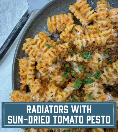 Sfoglini Pasta Recipe: pasta with sun-dried tomato pesto on a plate. With text overlay "Radiators with Sun-Dried Tomato Pesto"