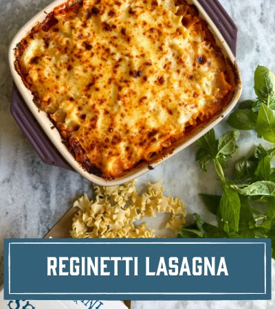 Sfoglini Pasta Recipe: baked pasta lasagna in a dish with fresh basil on a marble surface, labeled 'Reginetti Lasagna'.