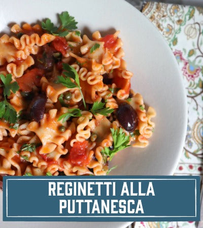 Sfoglini Pasta Recipe:  Pasta noodleswith vegetables and sauce on a white plate, labeled 'Reginetti alla Puttanesca'.