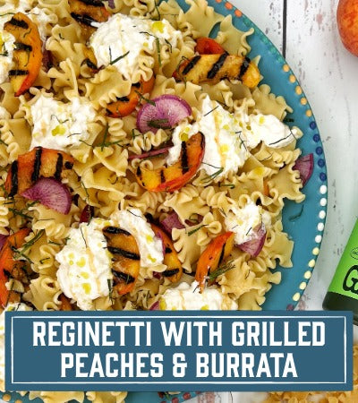 Sfoglini Pasta Recipe: salad with ruffled pasta, grilled peaches and burrata on a blue plate. With text overlay "Reginetti with Grilled Peaches and Burrata"