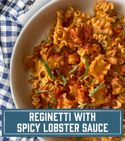 Sfoglini Pasta Recipe: Bowl of ruffled pasta with spicy lobster sauce on a checkered tablecloth. With text overlay "Reginetti with Spicy Lobster Sauce"