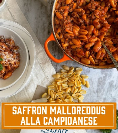Sfoglini Pasta Recipe: Pasta dish with text overlay 'Saffron Malloreddus Alla Campidanese' on a marble surface.