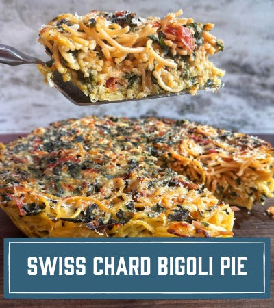 Sfoglini Pasta Recipe:  Swiss Chard Bigoli Pie with a slice being lifted on a wooden board. With text overlay "Swiss Chard Bigoli Pie"
