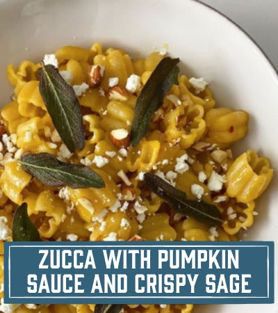 Sfoglini Pasta dish with pumpkin sauce, crispy sage leaves, and crumbled cheese in a white bowl. With text overlay "Zucca with Pumpkin Sauce and Crispy Sage"