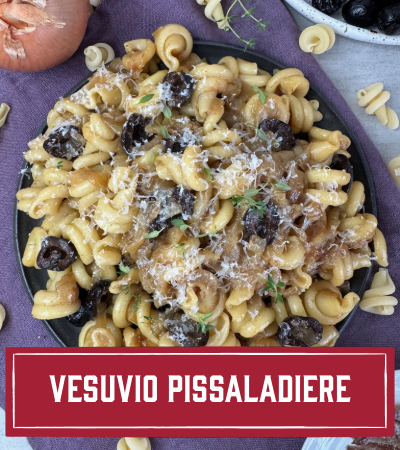 Sfoglini Pasta Recipe: Vesuvio Pissaladiere. Twisted pasta on a plate with olives, carmalized onions, and anchovies.