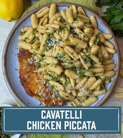 Cavatelli with chicken piccata on a plate with lemon and parsley.