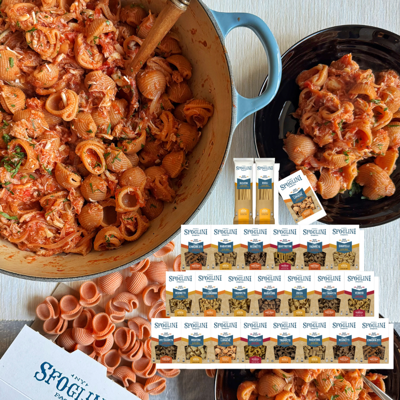 Pasta dish with a wooden spoon, Spolietto pasta packages, and Sfoglini packaging on a table. Pasta Club.